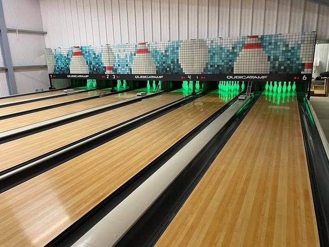 Polished ten-pin bowling lanes with the pins lit at the end