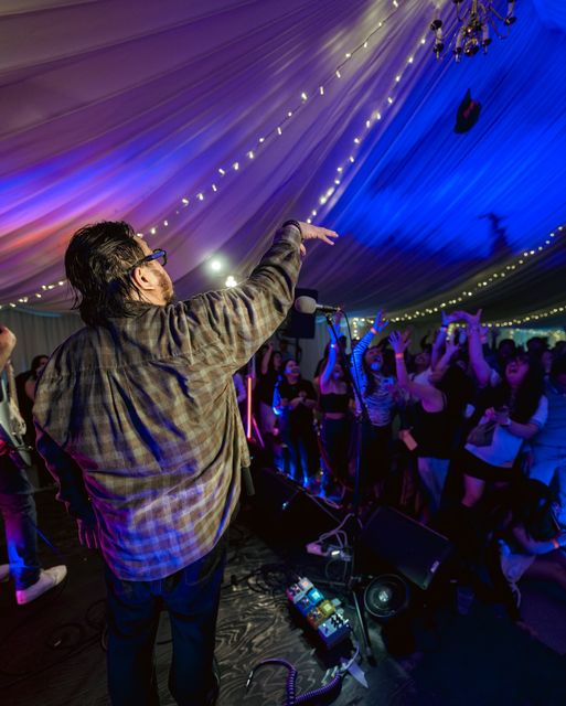 Singer on stage facing a packed marquee