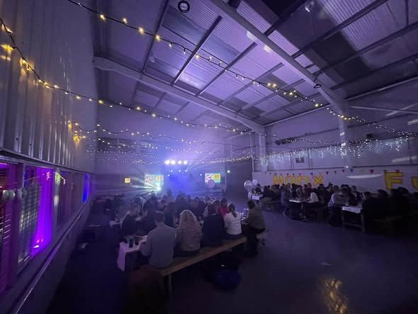 The hall with tables, fairy lights and a stage lit purple