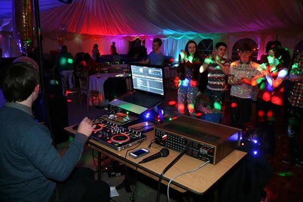 DJ desk with coloured lights inside the marquee