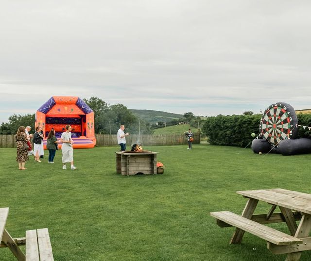 Families on the field with a bouncy castle and giant dartboard