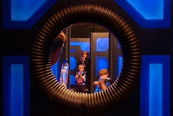 Children peering through the round portal in the Laser Blast arena