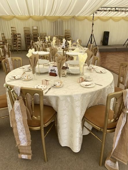 Round table laid with hessian chair sashes and gold chairs