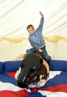 A boy riding the rodeo bull inside the marquee
