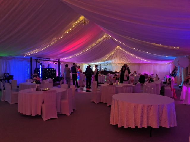 Wedding reception in the marquee with fairy lights and pink uplighting